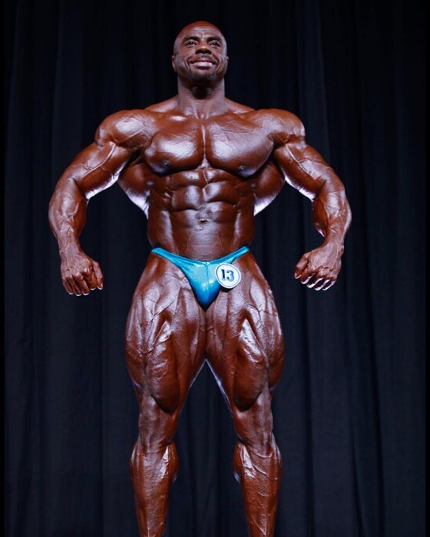 Toney Freeman posing on the bodybuilding stage looking aesthetic and huge