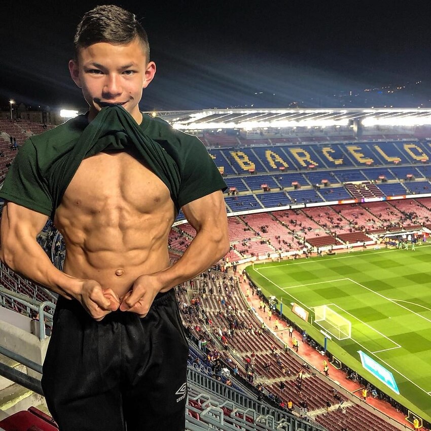 Tristyn Lee flexing his abs on a huge football stadium