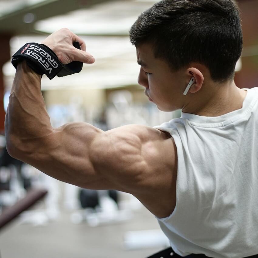 Tristyn Lee flexing his muscular and ripped arm and shoulder.