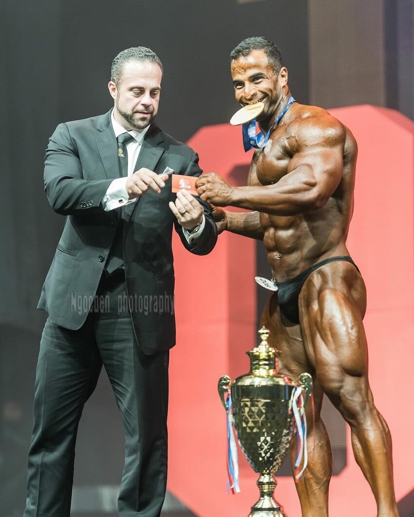 Ahmed Elsadany posing with a golden medal on the stage