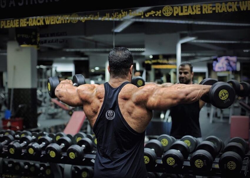 Ahmed Elsadany doing rear delt flys in the gym