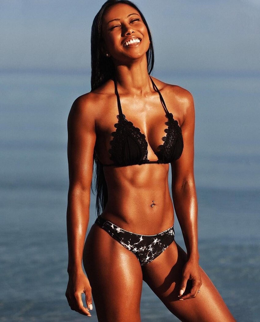 Melissa Carver smiling and posing in a bikini on the beach, looking fit and awesome