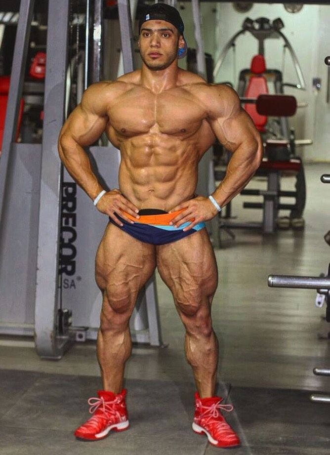 Mohammed Foda posing shirtless in the gym, looking massive and ripped