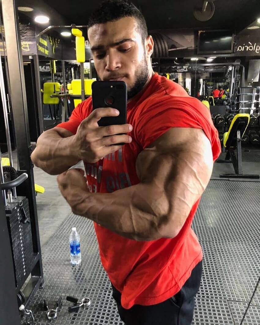 Mohammed Foda flexing his massive triceps in the mirror for a selfie