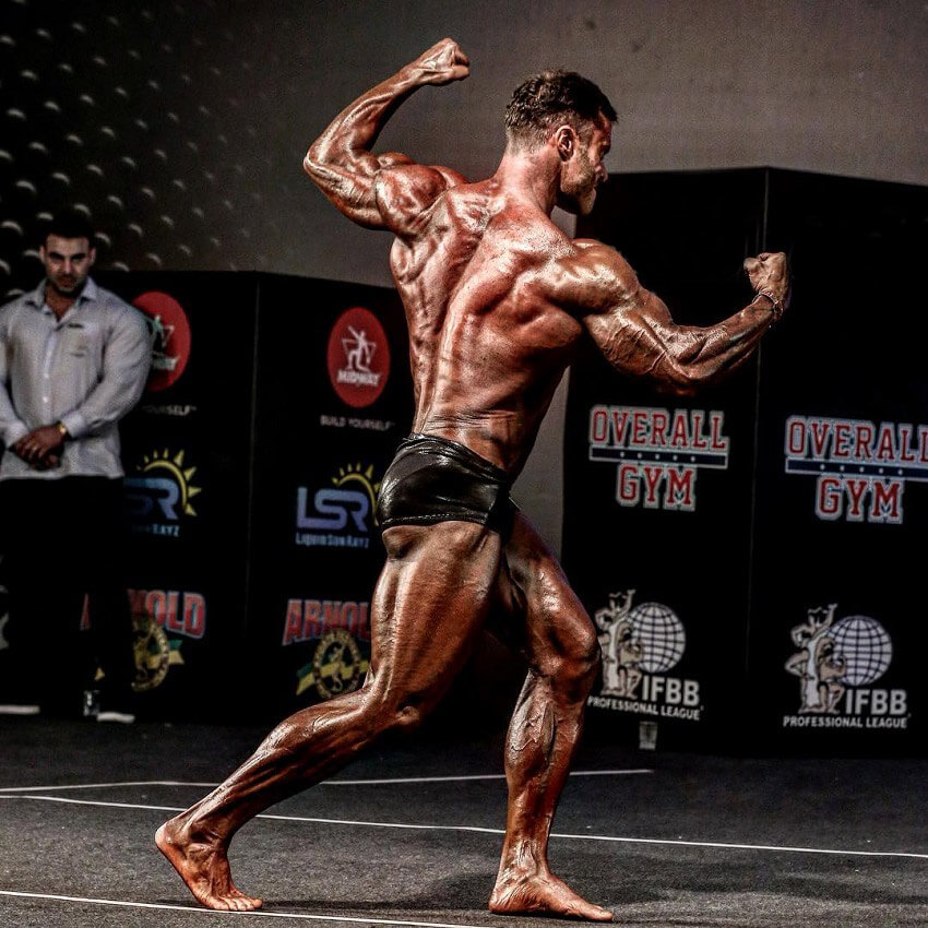 Renato Cariani flexing his back on a bodybuilding stage