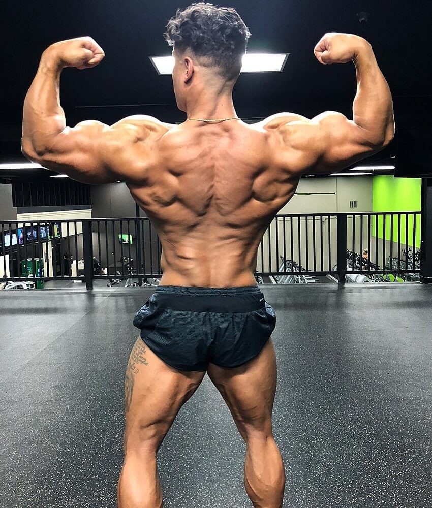 Stephen Pinto performing a shirtless rear double biceps flex