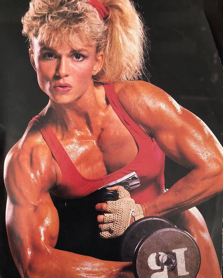 Tonya Knight posing with a dumbbell looking ripped and aesthetic