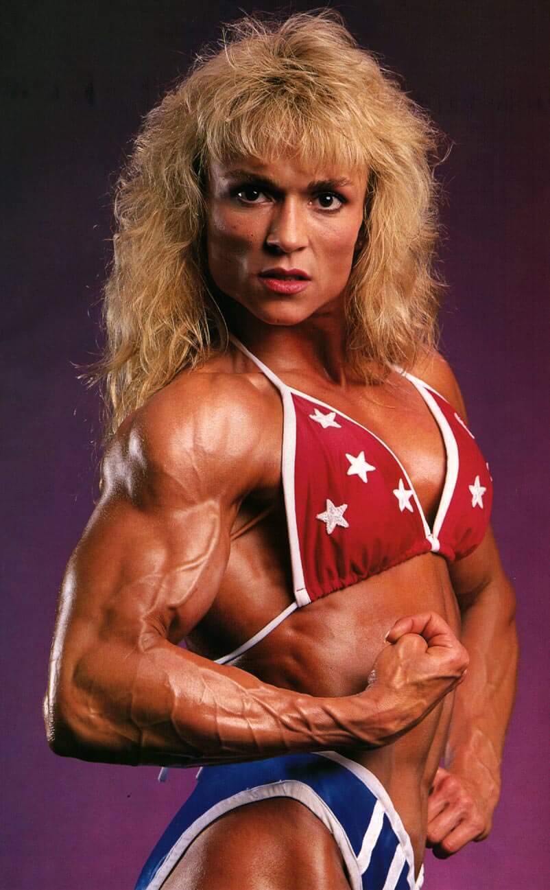 Tonya Knight flexing her biceps from the side, looking vascular and ripped