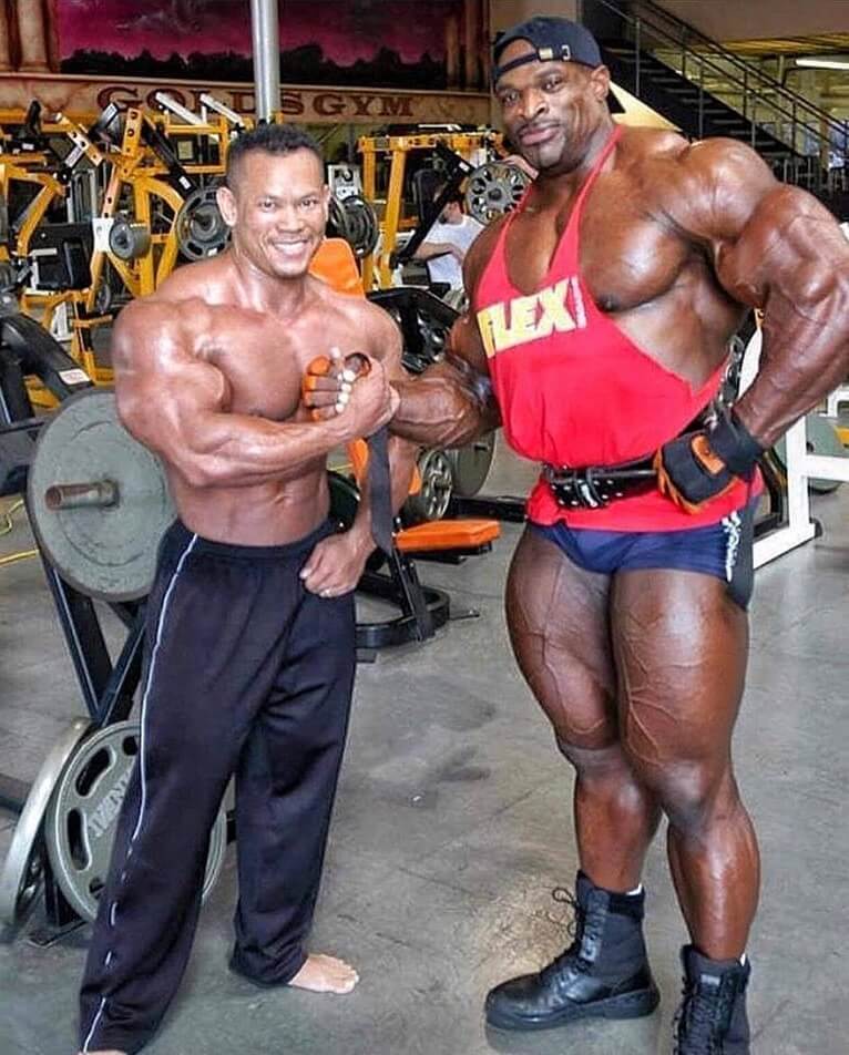 Kris Dim posing in the gym with Ronnie Coleman