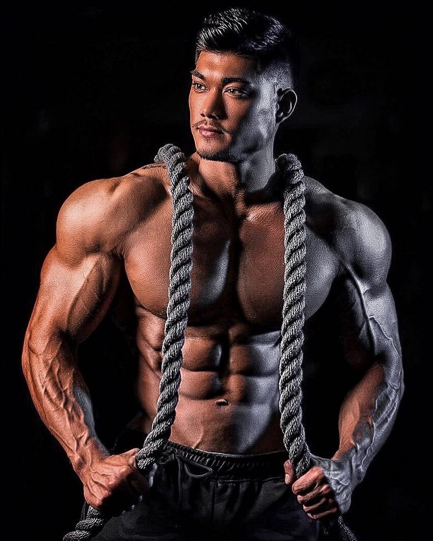 Nicolas Iong posing shirtless with training ropes around his neck