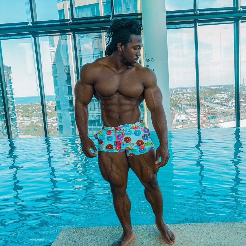 Kwame Duah posing shirtless by the pool looking swole and aesthetic