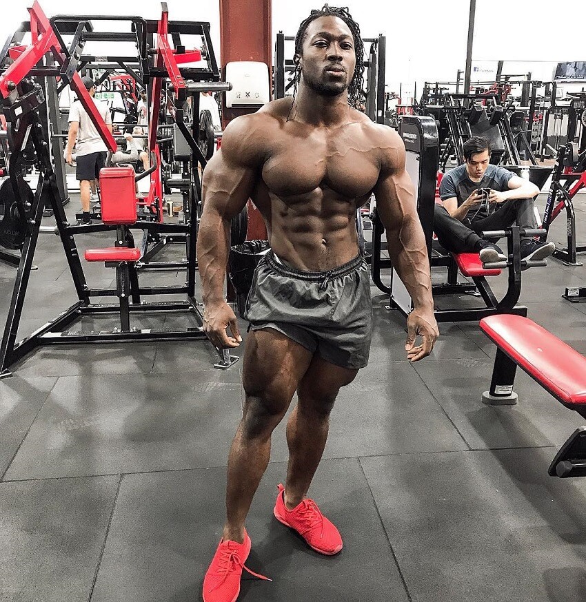 Kwame Duah posing shirtless in the gym