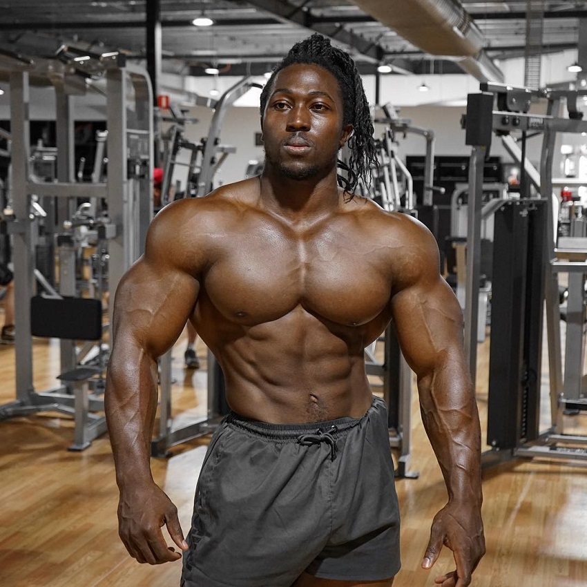 Kwame Duah posing shirtless in the gym