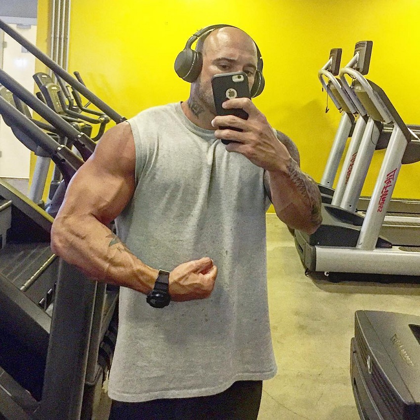 Marcello Rafaelli taking a selfie of his vascular and ripped arms in the cardio room