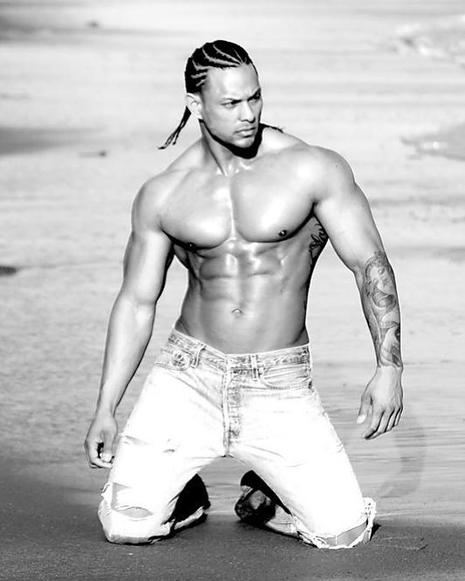 Mark Anthony posing on the beach in a fitness modeling event