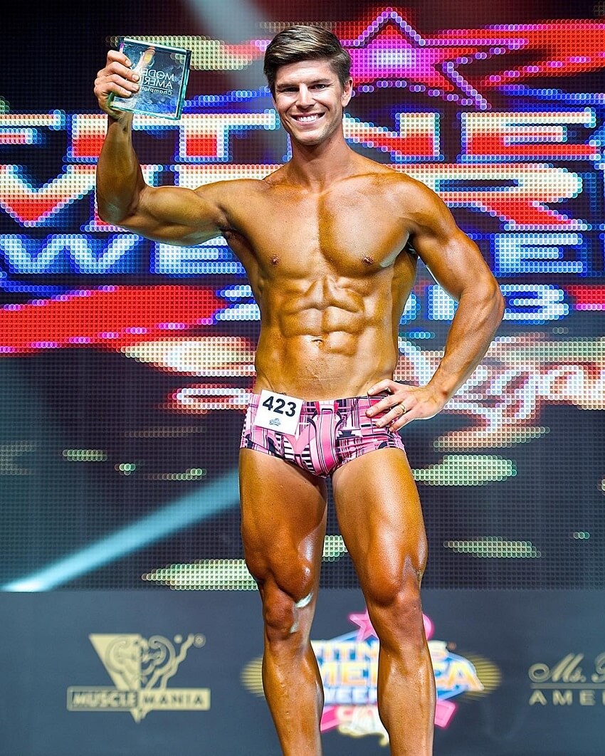 Mark Robinson posing with a trophy in a fitness show