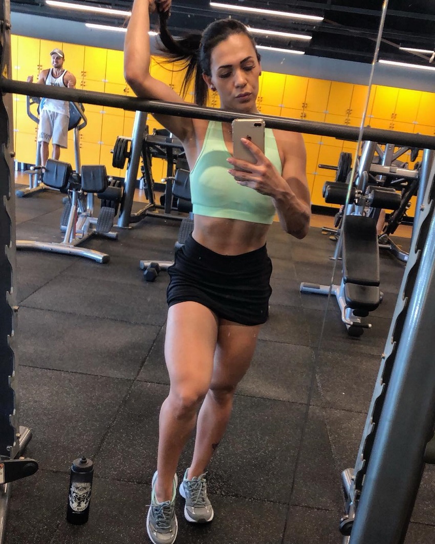 Ananda Nogueira taking a picture of herself in the gym, looking curvy and fit