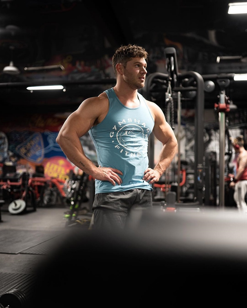 Chris Clark posing in a tank top in a gym