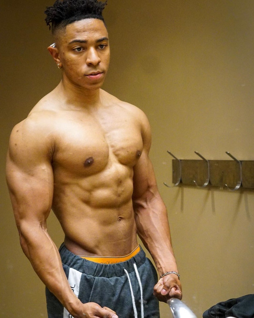 Evan Johnson posing shirtless in the gym locker room