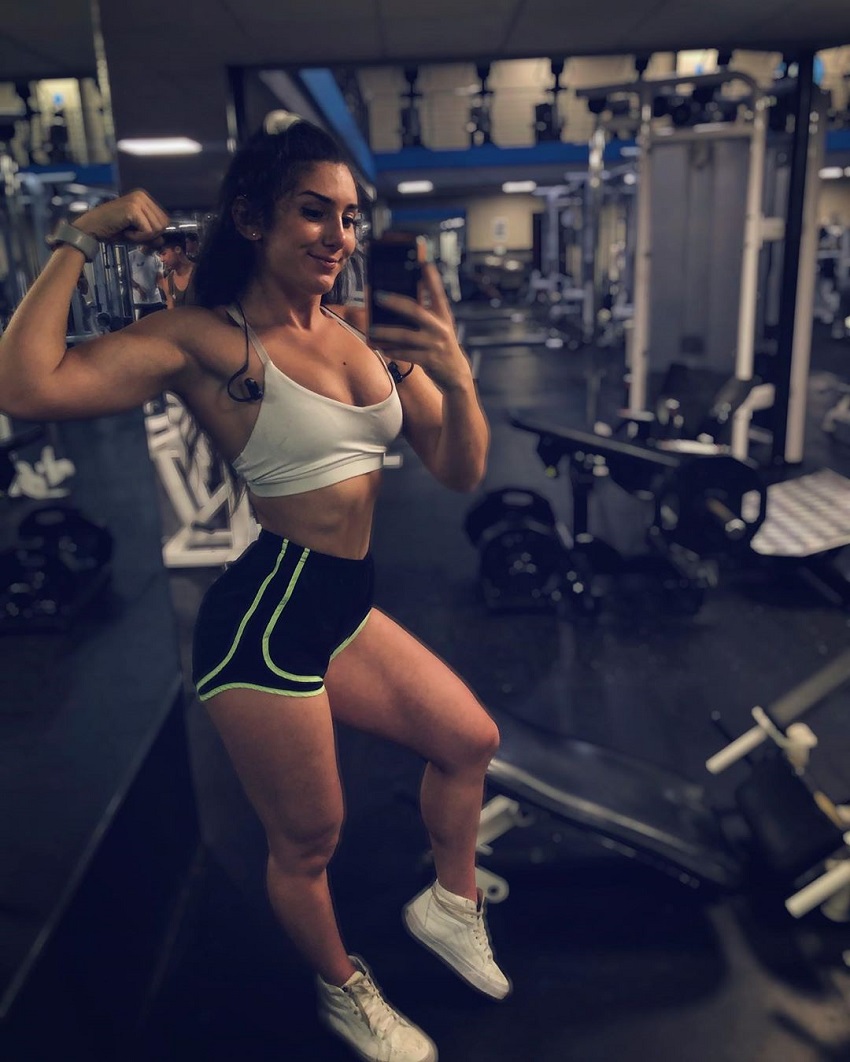 Jen Butters flexing her biceps in a gym selfie