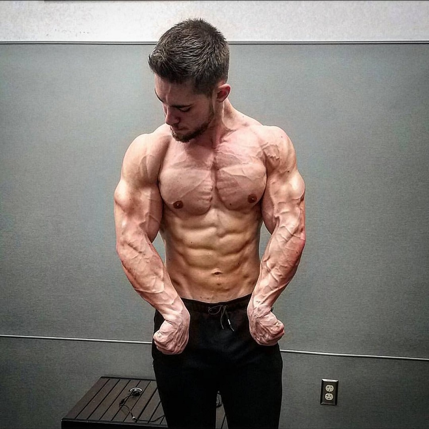 Jordan Strickland flexing his ripped upper body shirtless