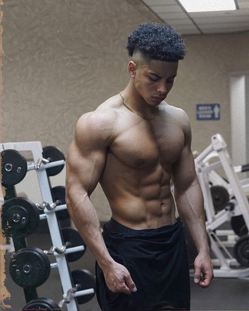 Michael Smith posing shirtless in the gym looking fit and lean