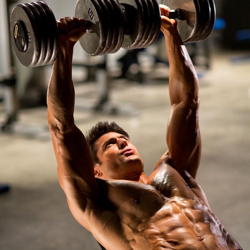 TJ Hoban doing heavy incline dumbbell press shirtless