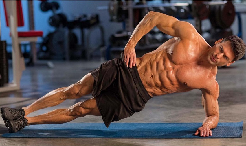 TJ Hoban doing side planks shirtless, looking shredded and muscular