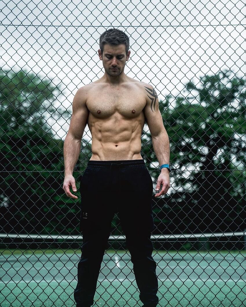 Alex Crockford posing shirtless outdoors