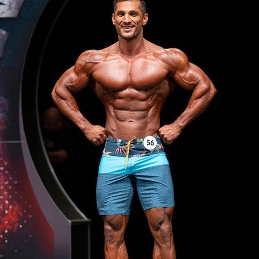 Akbar Sarbaz posing on the bodybuilding stage