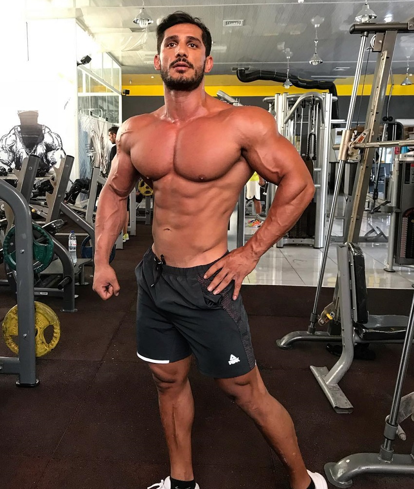 Akbar Sarbaz posing shirtless in the gym