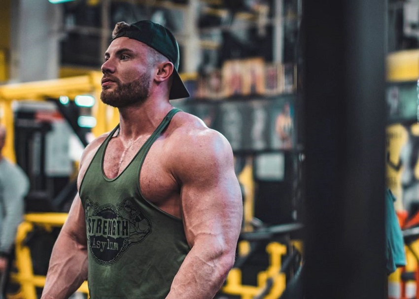 Luke Hulme standing in a green tank top in the gym