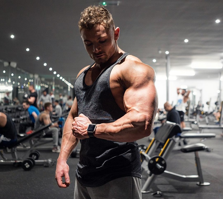 Luke Hulme flexing his arm in the gym