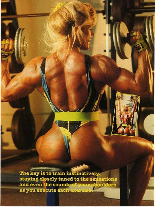 Sandy Riddell sitting on a bench doing dumbbell shoulder press