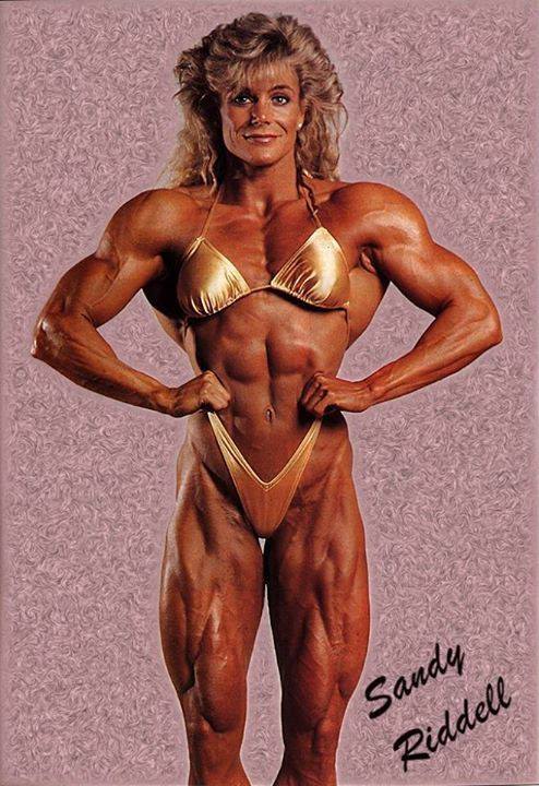 Sandy Riddell performing a front lat spread, looking ripped and muscular