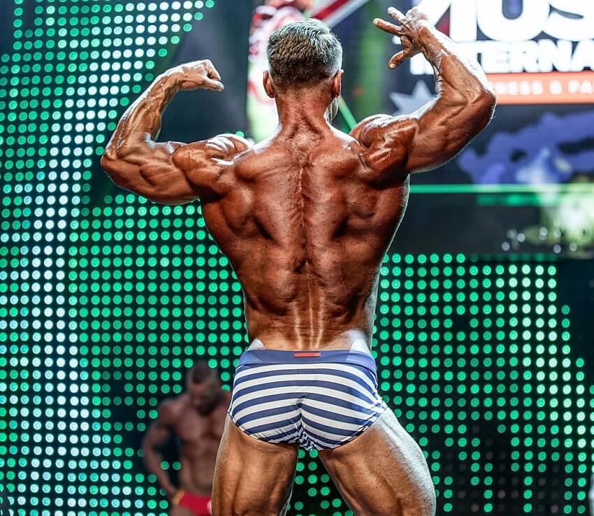 Dan Mazzola showcasing his incredibly ripped back muscles on the WBFF fitness stage