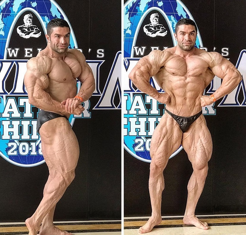 Majid Jameh Bozorg posing in front of Joe Weider's Mr. Olympia banner