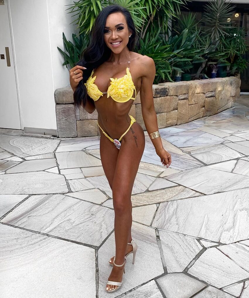 brooke wood posing in a yellow bikini looking fit and aesthetic