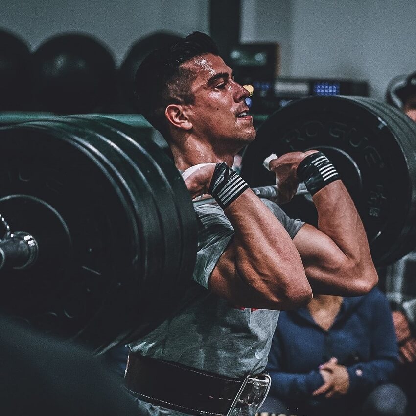 Garret Fisher lifting barbell loaded with weights in the gym