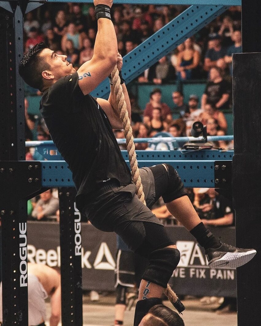 Garret Fisher climbing a rope during a CrossFit competition