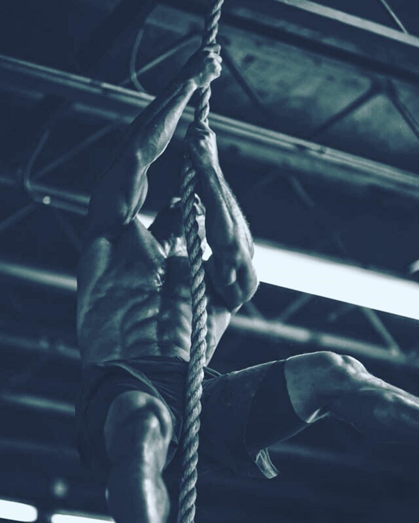 Neal Maddox climbing ropes during CrossFit training