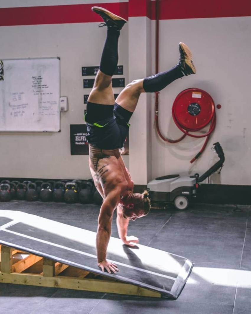 Rasmus Wisbech Andersen doing a handstand shirtless